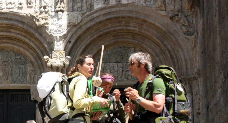 Pilgrims on the Camino de Santiago in the door Platerias after reaching Santiago de Compostela