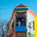 The famous colorful streets of El Caminito with the famous statue of Pope Francis waving at the crowd.