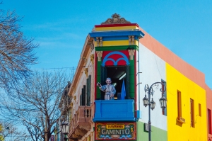 The famous colorful streets of El Caminito with the famous statue of Pope Francis waving at the crowd.