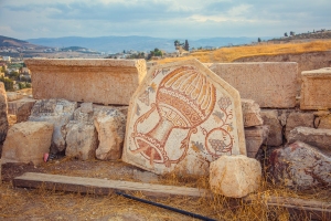 Un antiguo mosaico romano con jarra de vino y uva en la ciudad de Jerash, Jordania