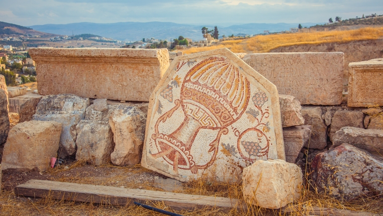 Un antiguo mosaico romano con jarra de vino y uva en la ciudad de Jerash, Jordania