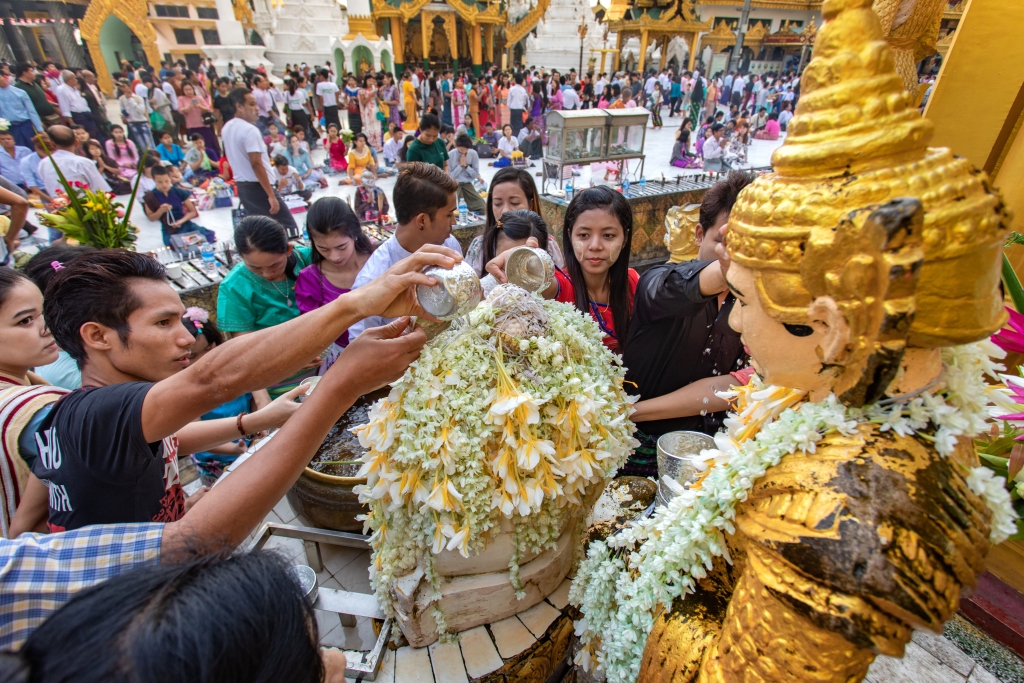 People pouring water on buddha statue at the ceremony in the Shwedagon pagoda in Yangon, Myanmar.