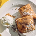 Pastel maltés de dátiles llamado Imqaret servido con helado en el plato.