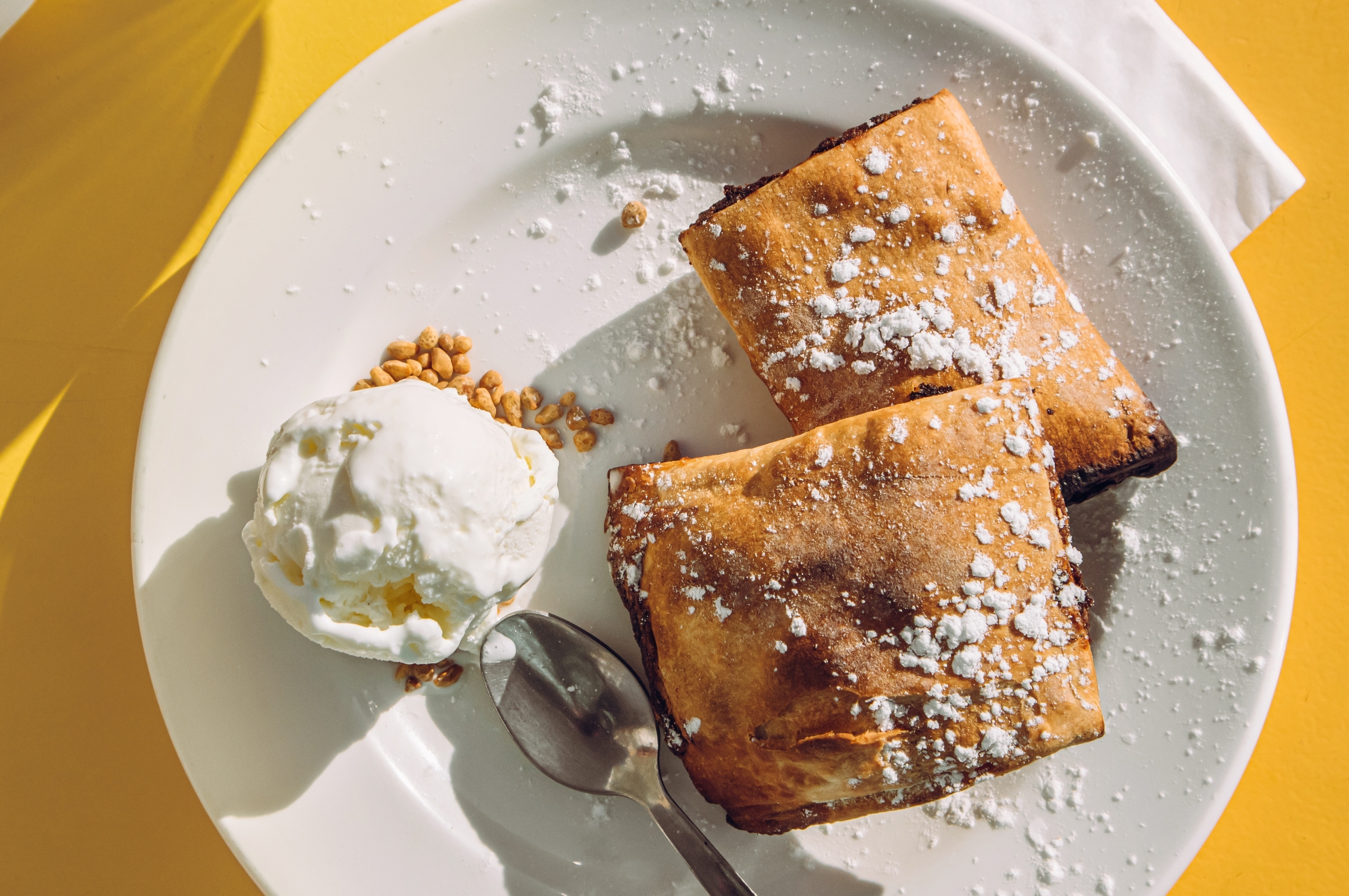 Pastel maltés de dátiles llamado Imqaret servido con helado en el plato.