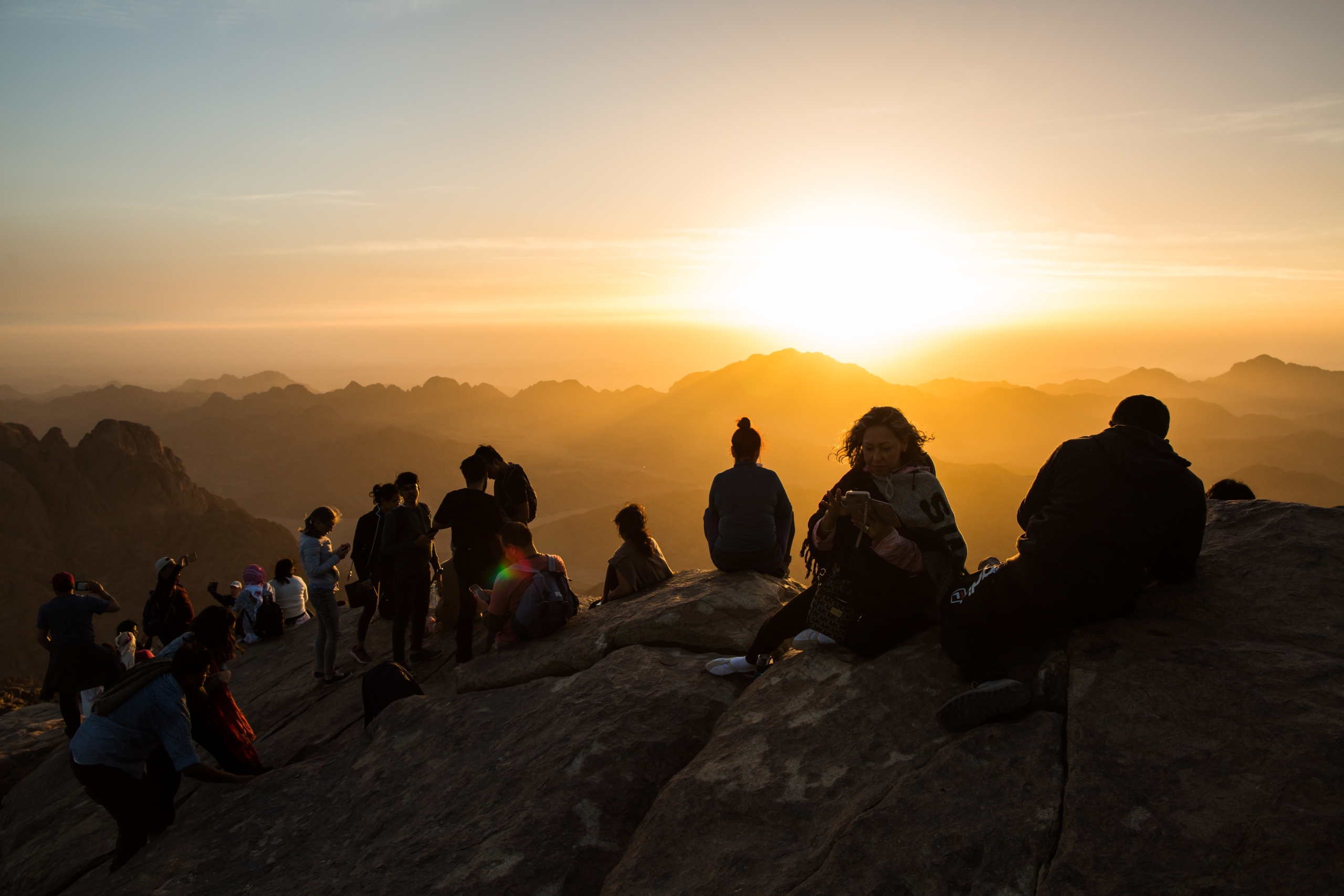 Peregrinos y turistas mirando el amanecer en la cima del Monte Sinaí