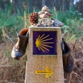 Hiking boot and stone on the stone sign, symbol of the Camino de Santiago