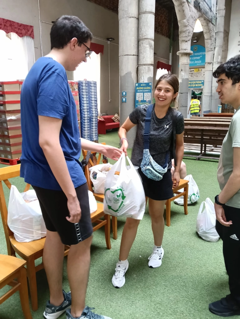 Young volunteers from Mensajeros de la Paz distribute food at the cathedral.