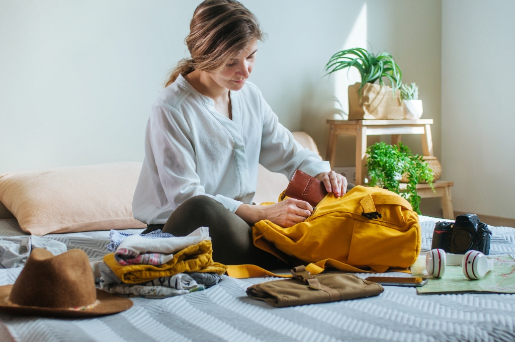 Young woman packing her backpack