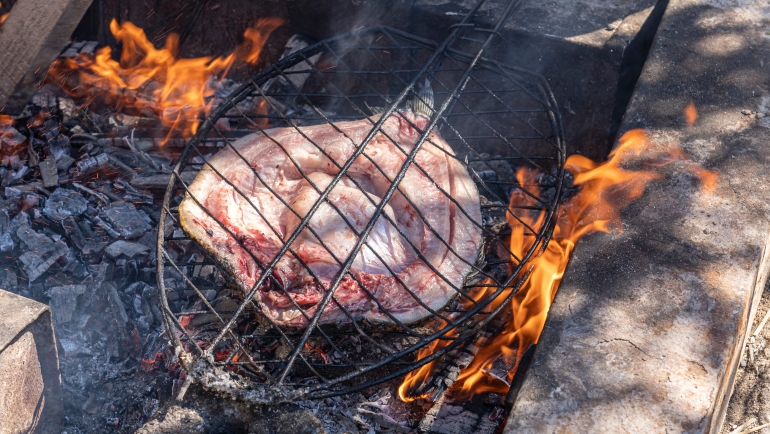 Preparing and grilling Masgouf over an open fire in the southern marshes of Iraq