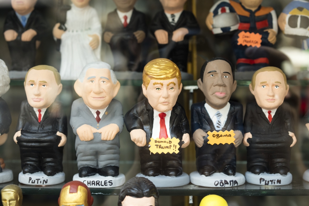 Group of Caganers, a catalan figure.In this case:Vladimir Putin, Prince Charles, Donald Trump and Obama are defecating. These figures are placed in nativity scenes.