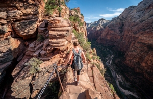 Yong female summiting to the top of Angels Landing, Zion National Park.