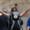 A pilgrim celebrates her arrival at the Plaza do Obradoiro in Santiago de Compostela after completing the Camino de Santiago.