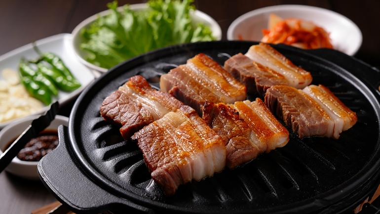 Traditional Korean barbecue Samgyeopsal with side dishes