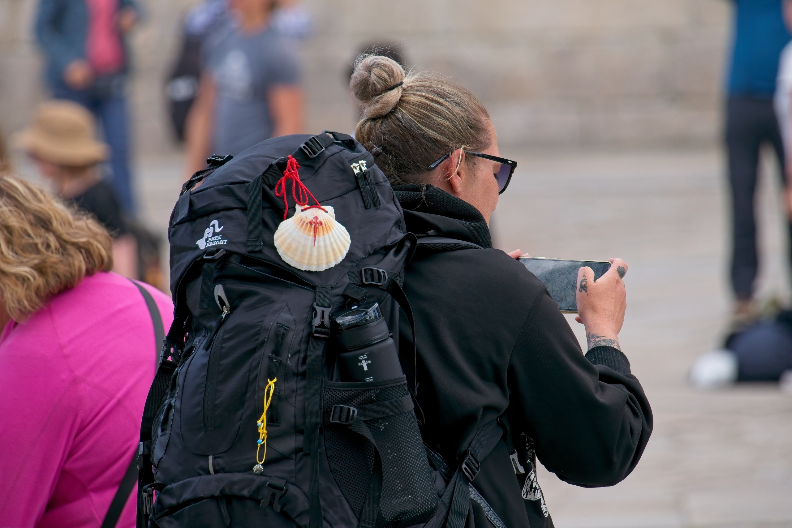 pilgrim woman capturing smartphone photos near the cathedral of santiago de compostela