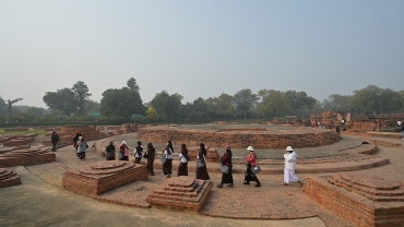 Buddhist pilgrims circumambulate the Dharmarajika Stupa in Sarnath, India