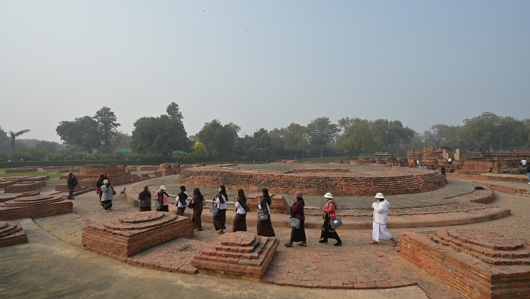 Buddhist pilgrims circumambulate the Dharmarajika Stupa in Sarnath, India