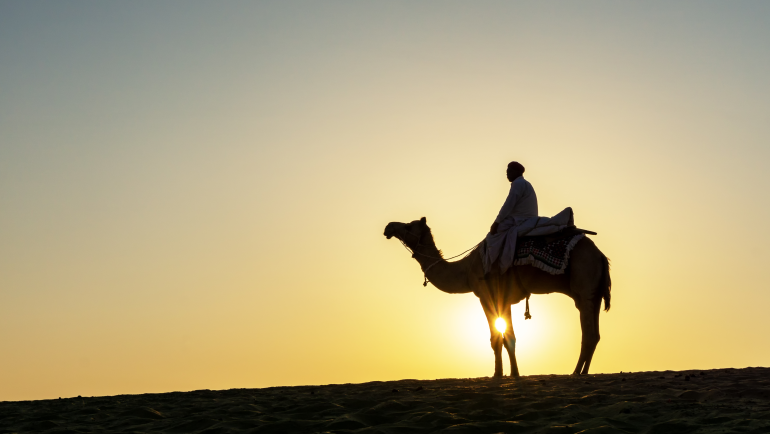 Silhouette,Of,Indian,Man,And,Camel,During,Sunrise,At,Thar