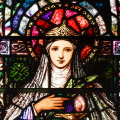 Detail of the stained glass window in the corridor behind the chancel, depicting St. Brigid holding her lamp.