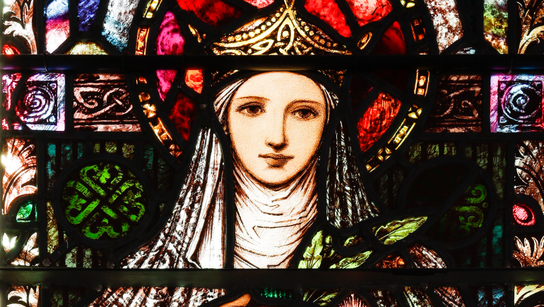 Detail of the stained glass window in the corridor behind the chancel, depicting St. Brigid holding her lamp.