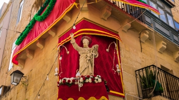 Estatua de San Pablo decorada en un pedestal en la esquina de la calle en La Valeta