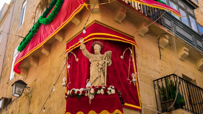 Estatua de San Pablo decorada en un pedestal en la esquina de la calle en La Valeta