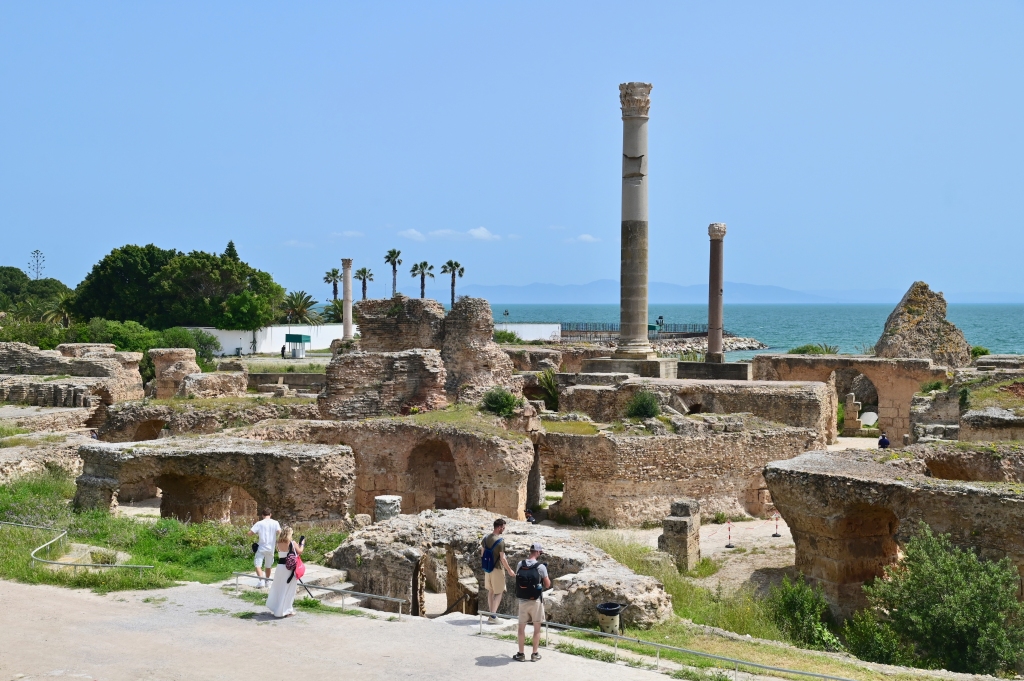 Tourists walking among the ancient Roman ruins at the Baths of Antoninus, a UNESCO World Heritage Site.