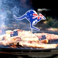 Icónica barbacoa australiana cerca de muchas costillas de cocina, salchichas y bistec, al aire libre en el jardín.