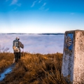 Pilgrim walking on the Camino de Santiago, above a sea of ​​clouds in the middle of nature