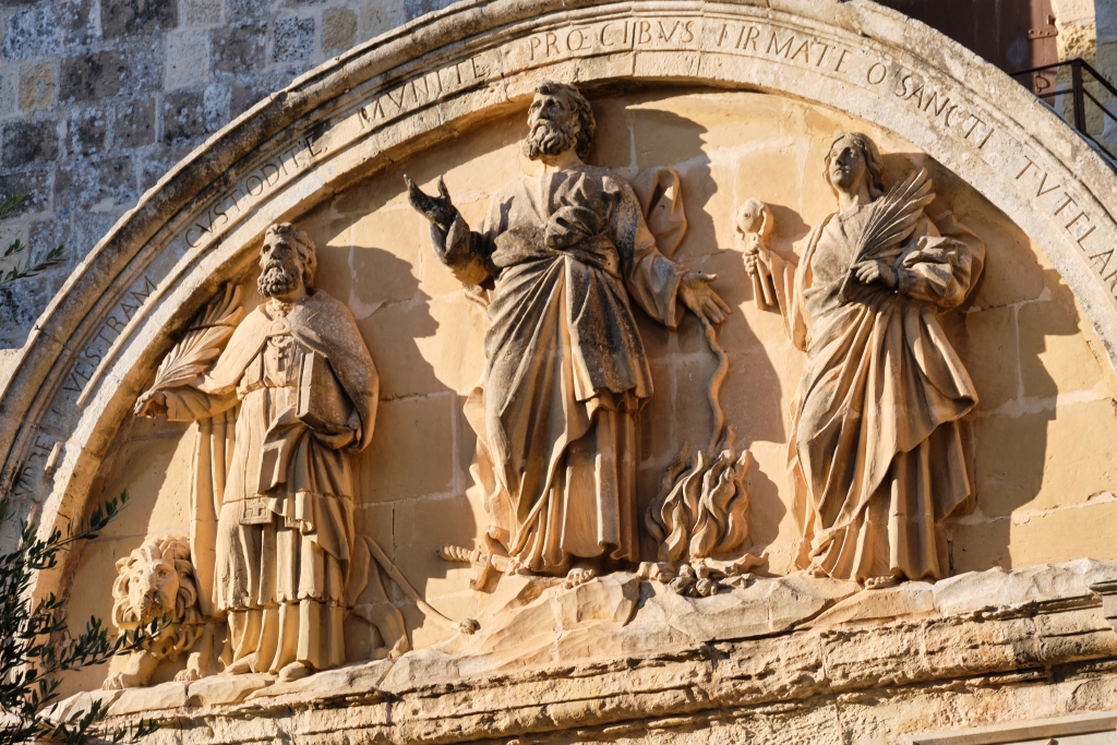 Relief on the back of the Main Door of Mdina Cathedral depicting the patron saints of Malta: Saint Paul in the center with Saint Publius and Saint Agatha on either side