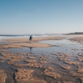 Lone woman walking along the low tide beach in Portugal, on the Portuguese Way to Santiago