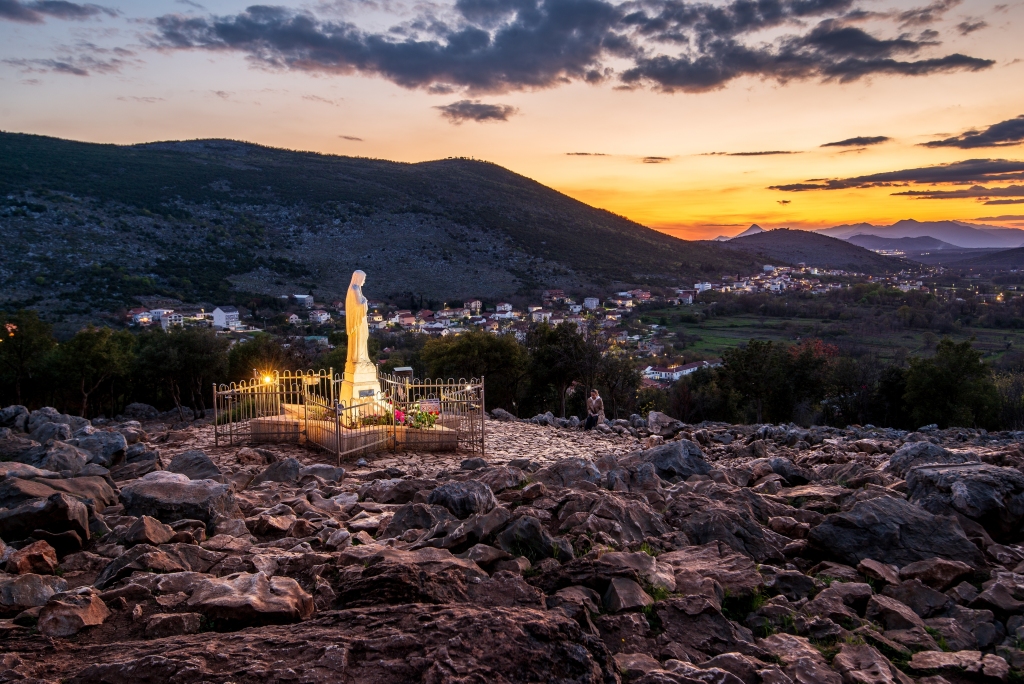 Apparation hill Podbrdo in Medjugorje in sunset with statue of Gospa