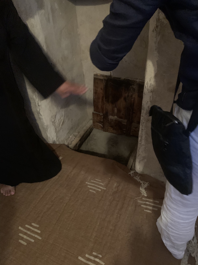 A monk shows the hiding place of the manuscripts in the wall of the Anba Makar fort.
