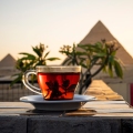 A cup of hibiscus tea in front of the pyramids of Giza