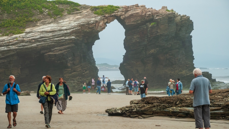 Visitors exploring Cathedral Beach at low tide