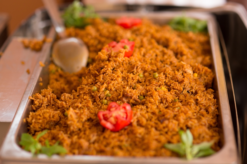 Ghanaian jollof rice with fresh vegetables served at a wedding.