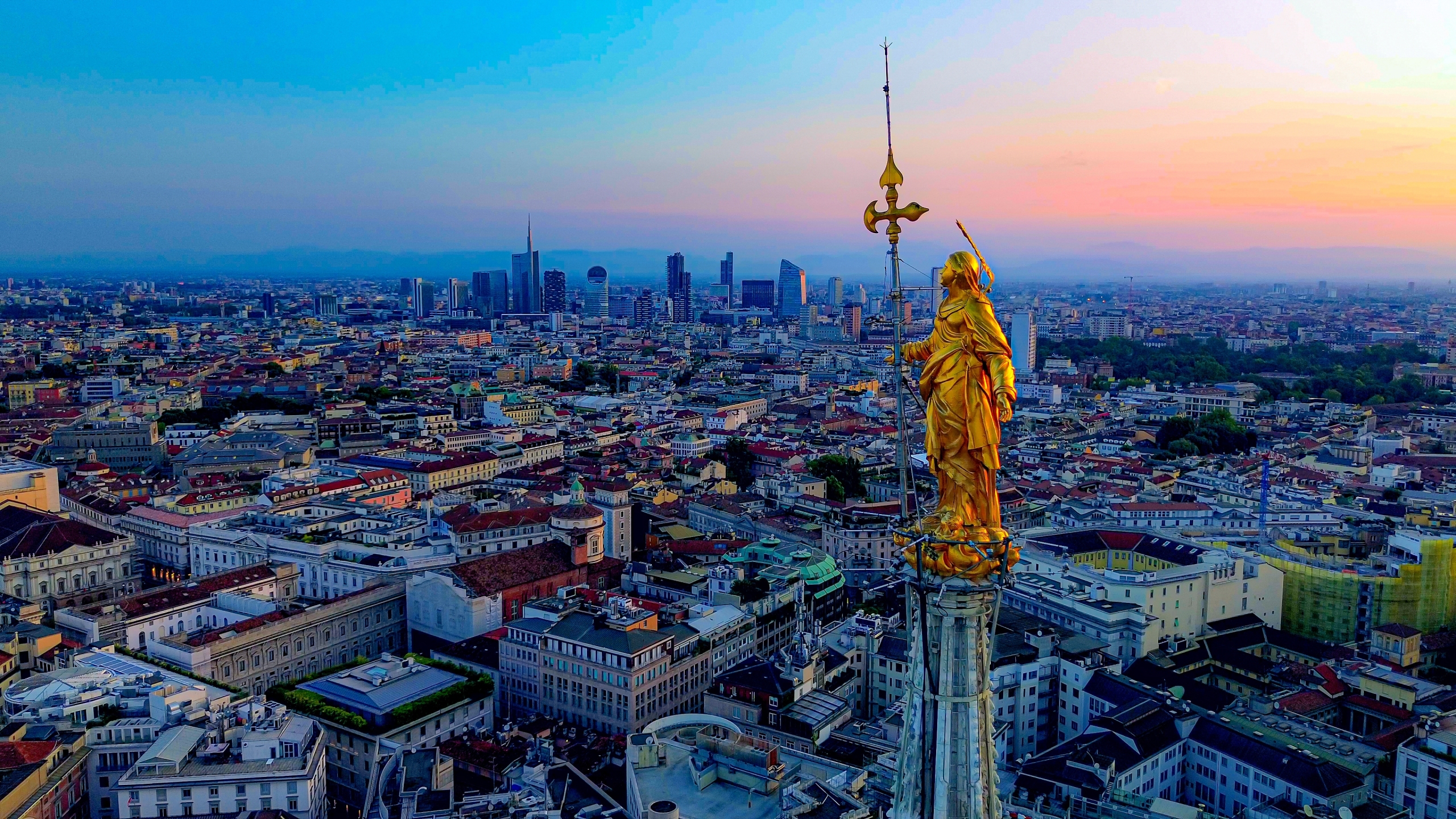 An aerial view of the golden, tallest statue of the Virgin (Madonnina) on the central spire of the Duomo at Milano, Italy